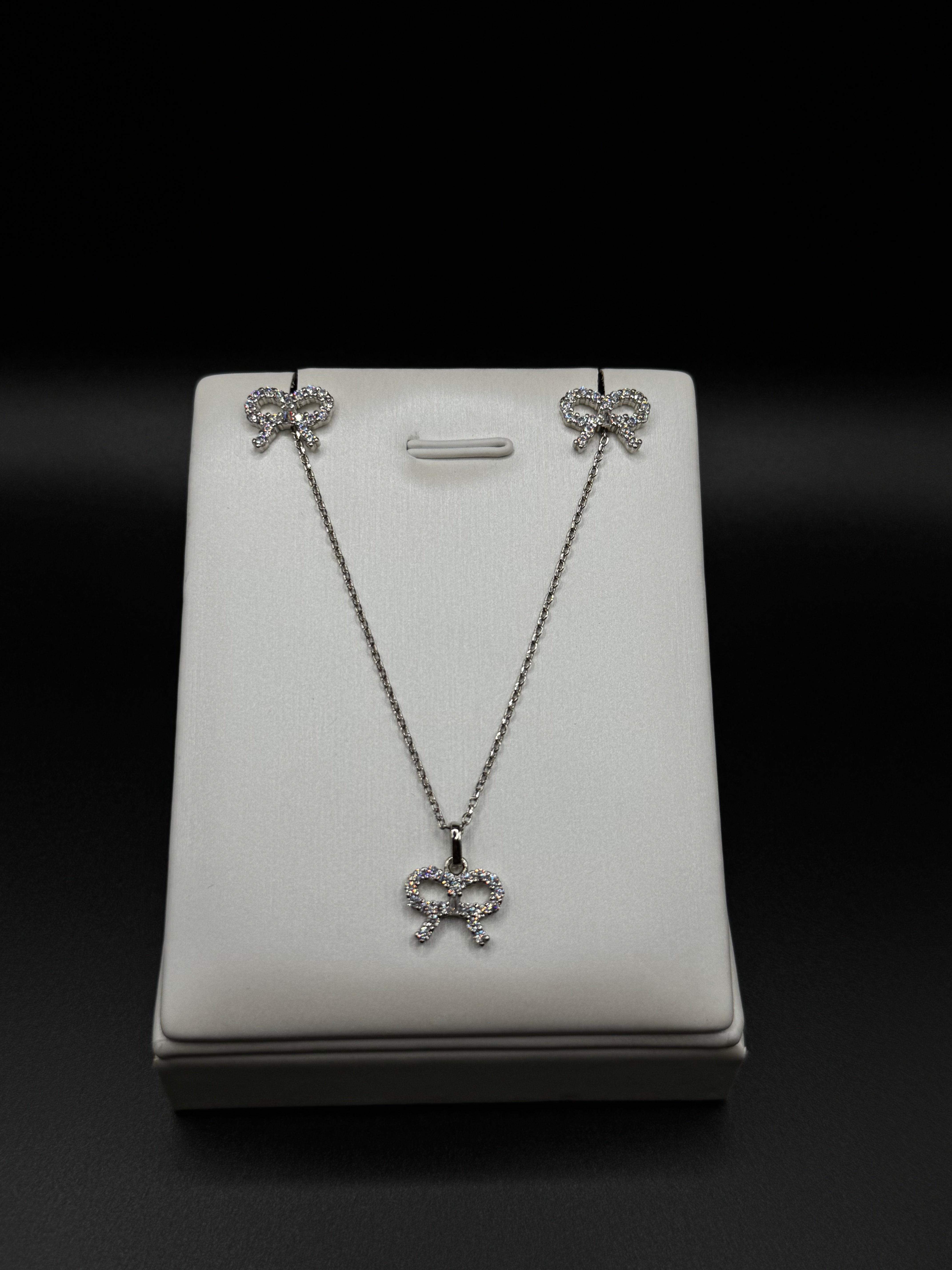 Bow-shaped set in rhodium plating with clear zirconia
