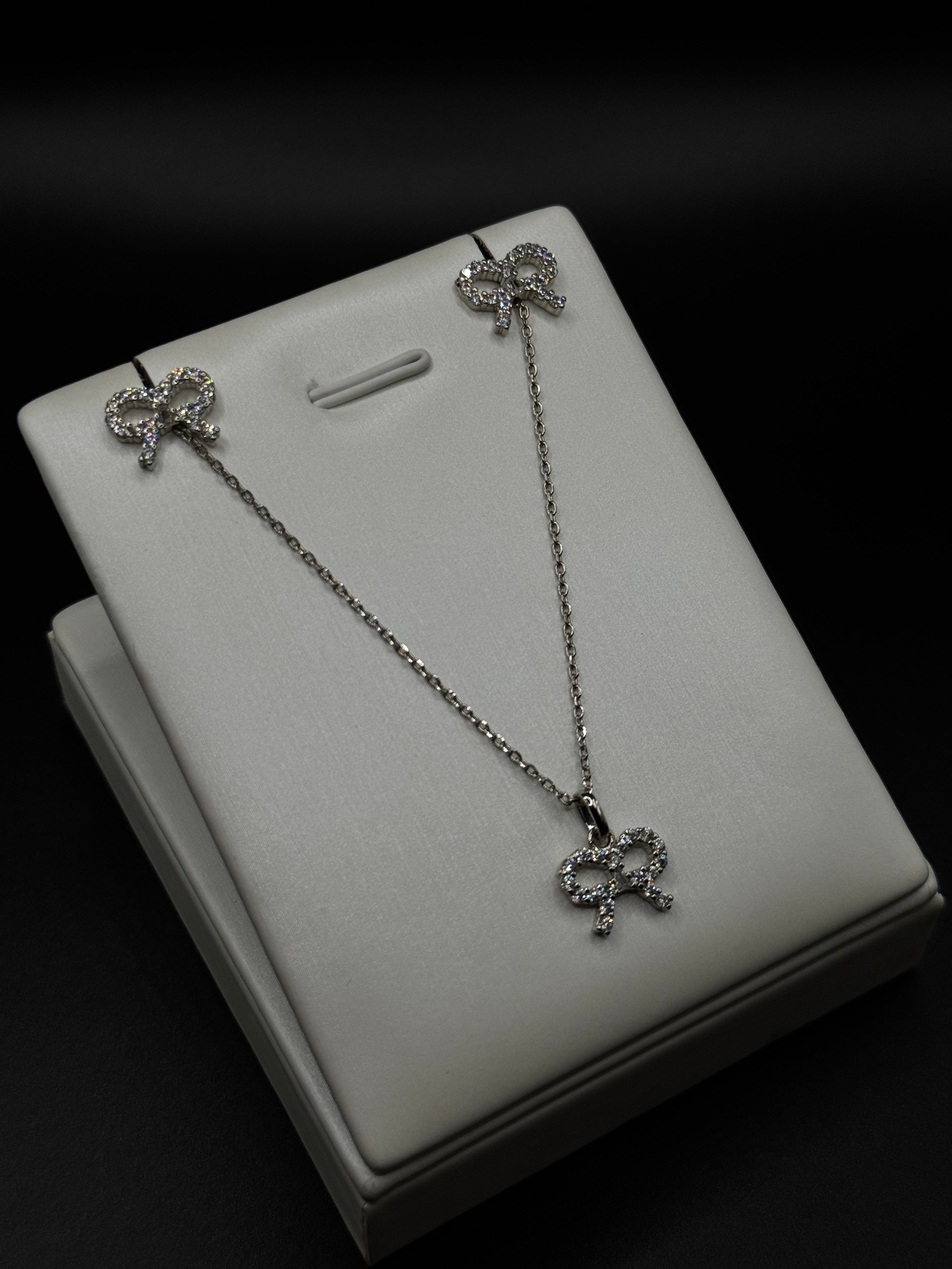 Bow-shaped set in rhodium plating with clear zirconia