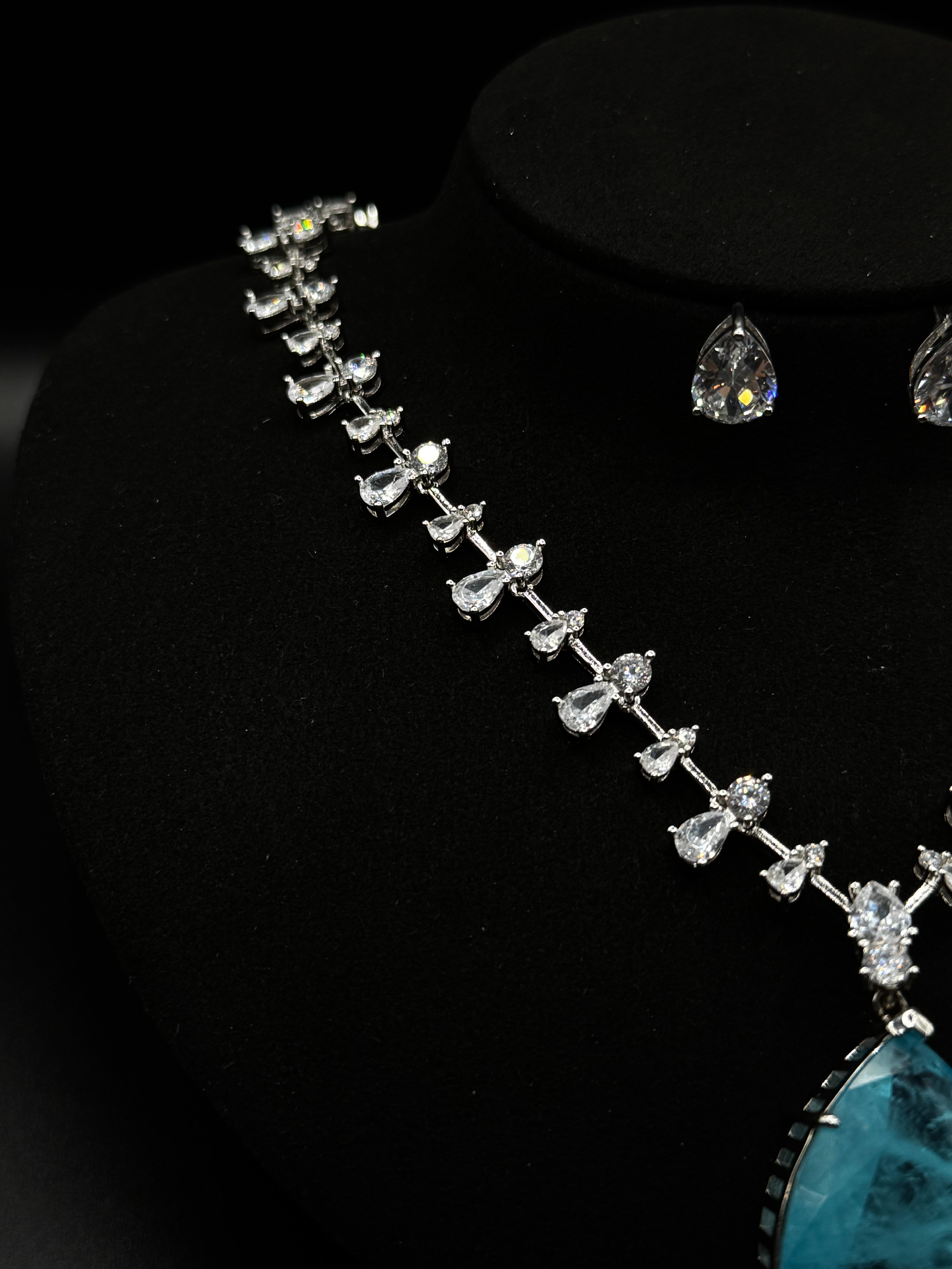 Luxury rhodium-plated jewelry set with a teardrop-shaped turquoise fusion stone pendant