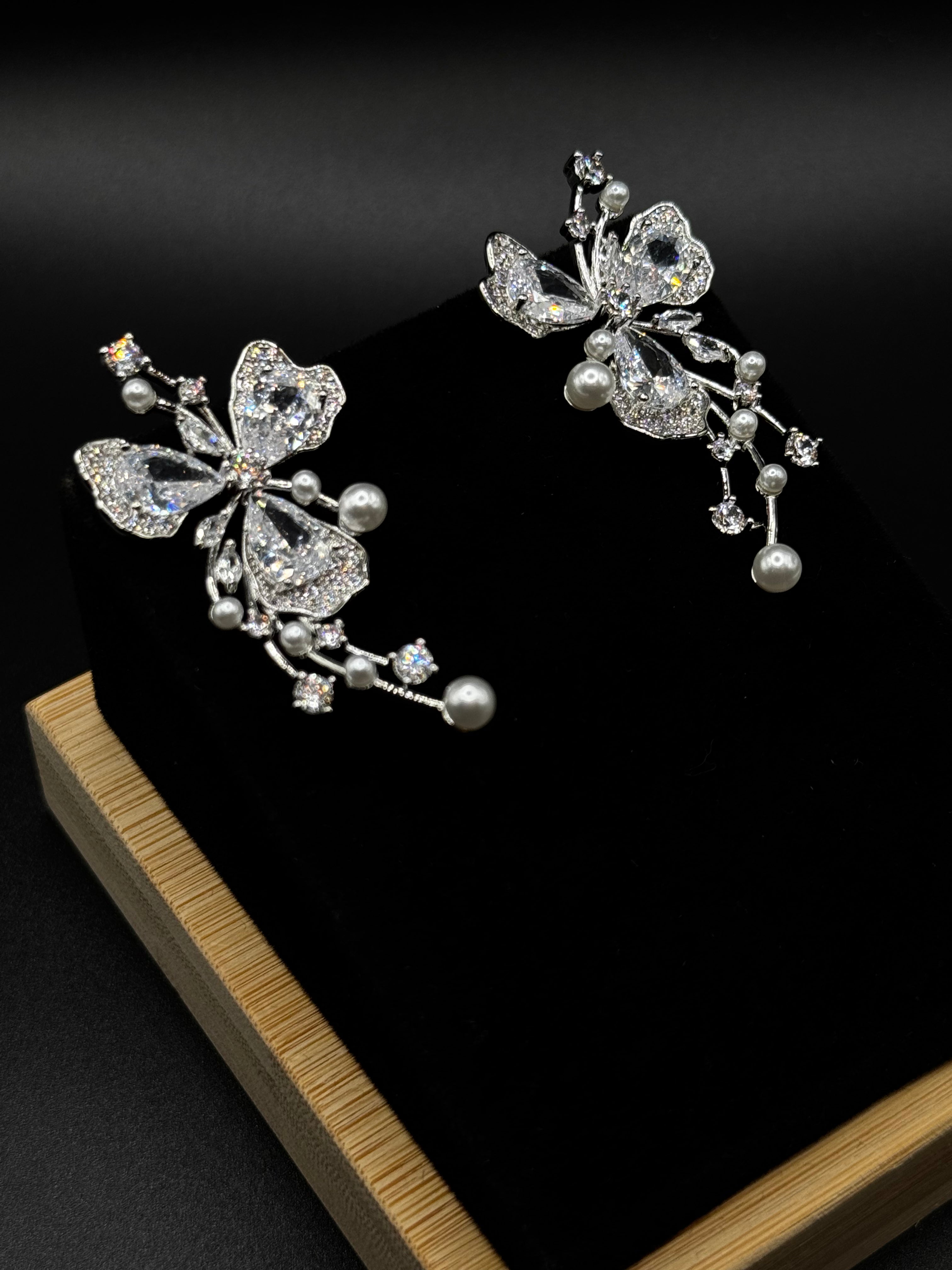 Floral shaped earrings encrusted with clear zirconia and pearl details