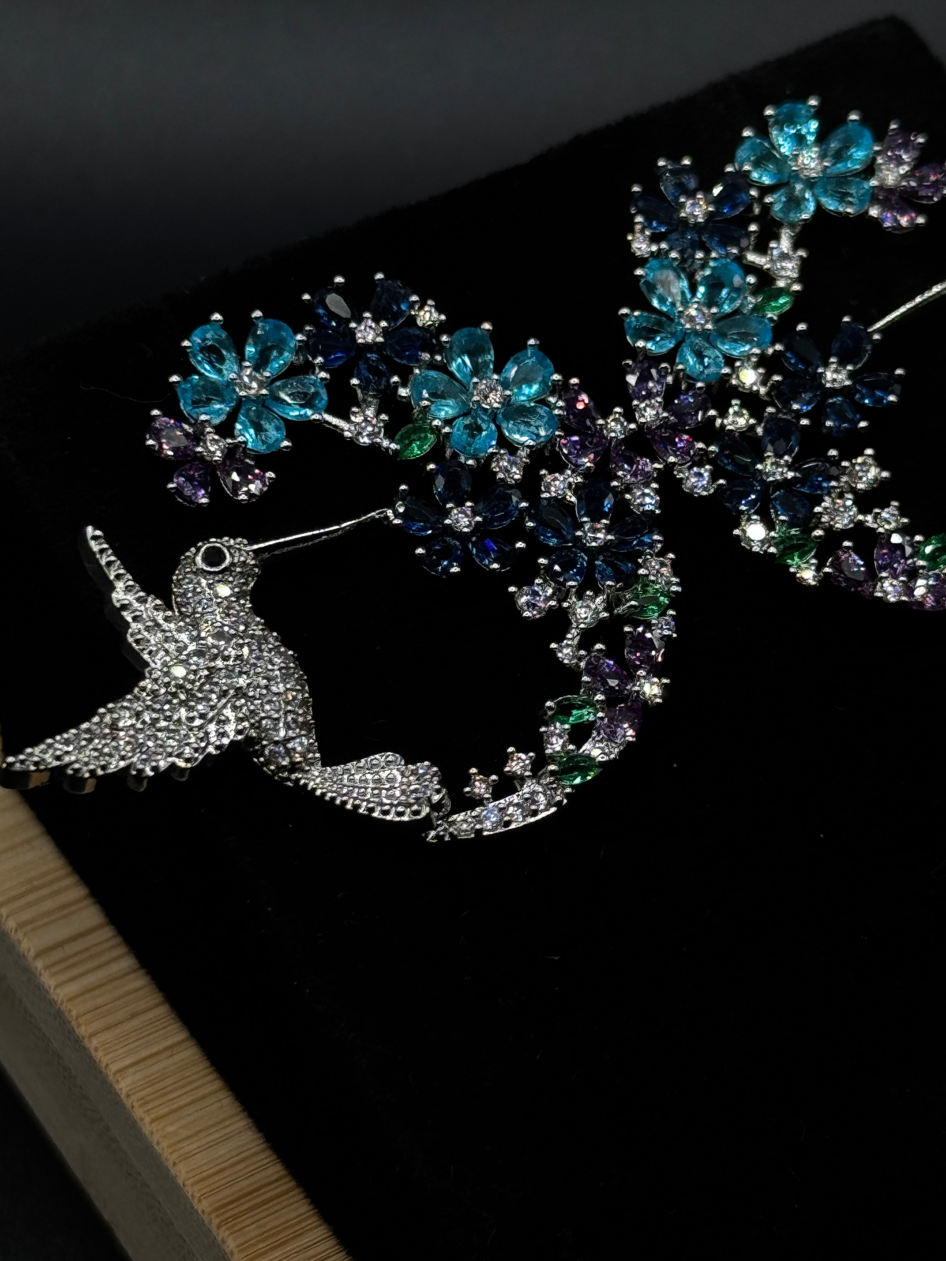 Hummingbird earring encrusted with crystal, aqua, and amethyst zirconia stones